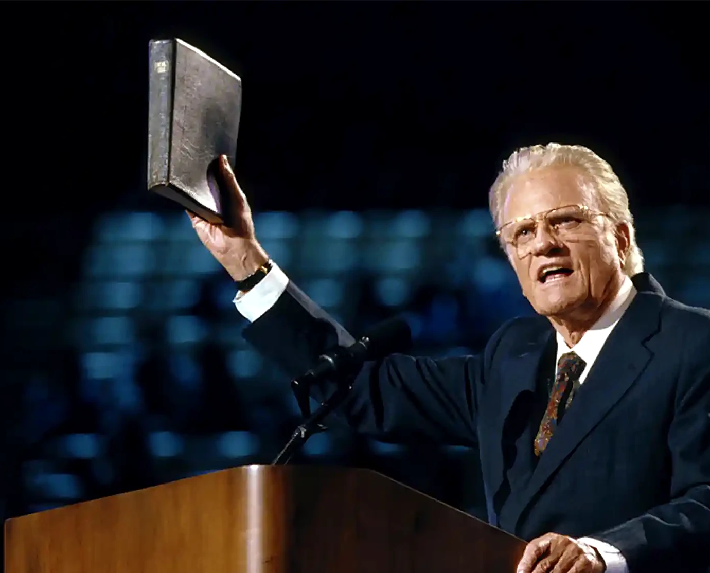Billy Graham preaching with his Bible raised, the evangelist behind the Billy Graham School of Evangelism Online