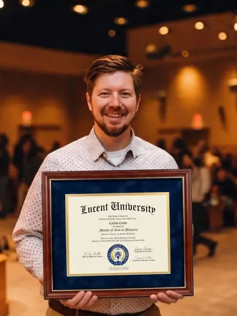 Diplômé d’un bachelor de Lucent University tenant son diplôme à l’église